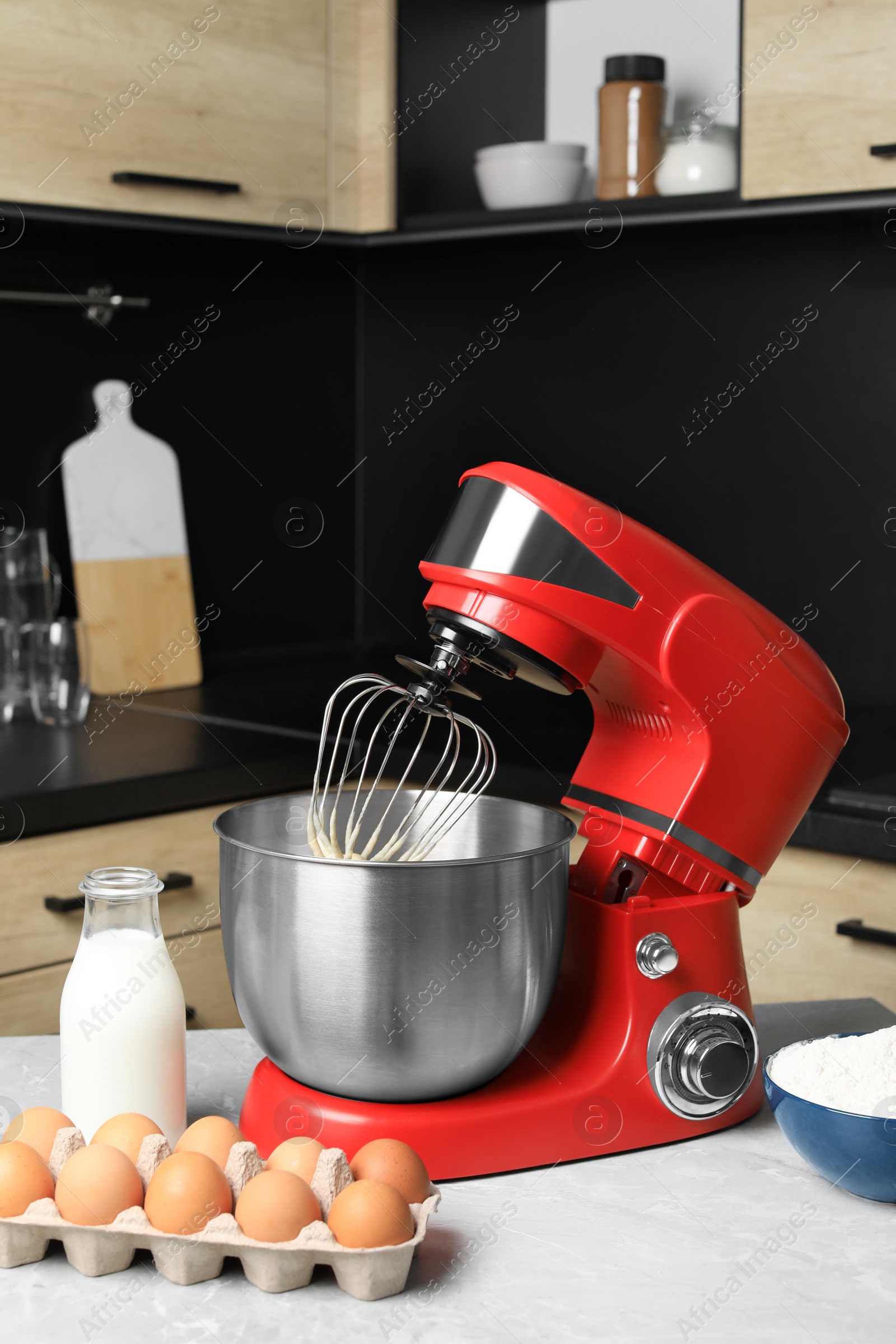 Photo of Modern stand mixer and ingredients on table in kitchen. Home appliance