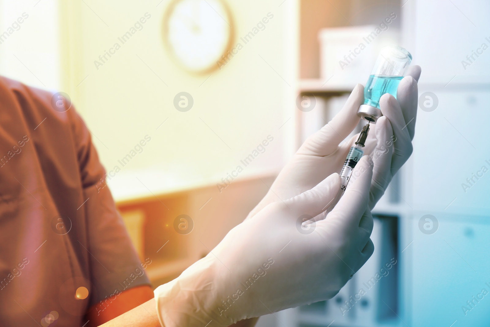 Image of Doctor filling syringe with medication from vial indoors, closeup