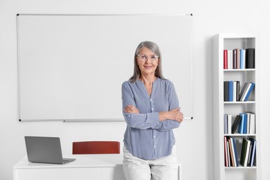 Photo of Portrait of professor near whiteboard in classroom