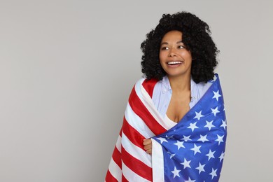 4th of July - Independence Day of USA. Happy woman with American flag on light grey background, space for text
