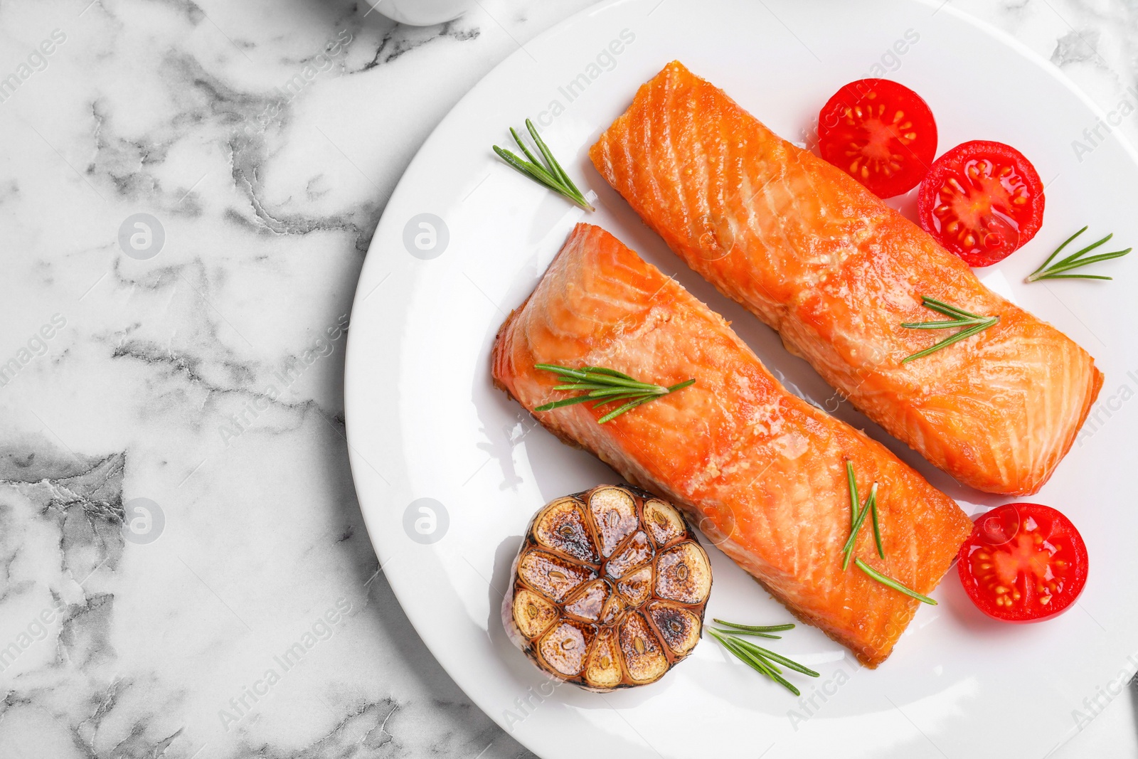 Photo of Delicious roasted fish served on white marble table, flat lay