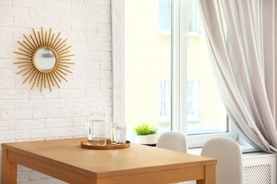 Wooden dining table in modern room interior. Space for text