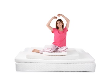 Woman sitting on mattress pile against white background