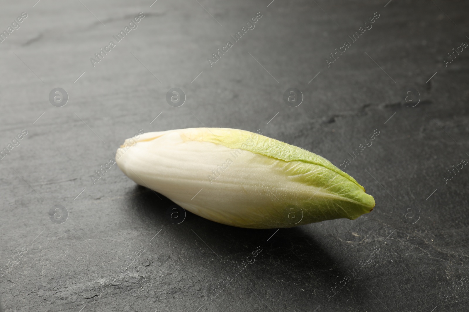 Photo of Fresh raw Belgian endive (chicory) on black table