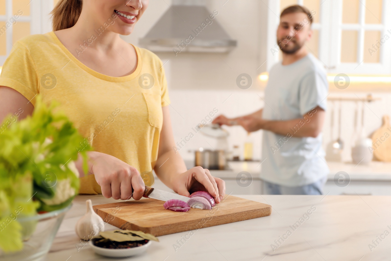 Photo of Woman cutting onion to make bouillon in kitchen. Homemade recipe