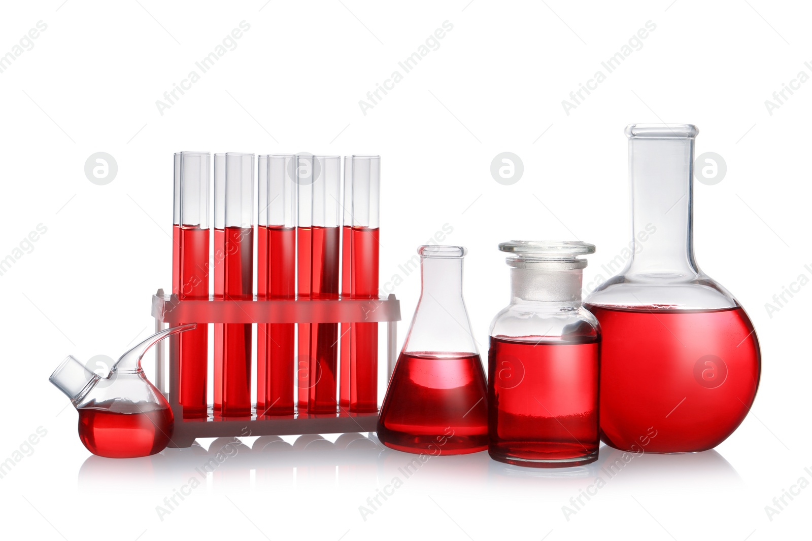 Photo of Set of laboratory glassware with red liquid on white background