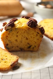 Photo of Delicious pumpkin bread with pecan nuts on tablecloth, closeup