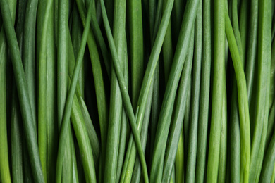 Fresh green spring onions as background, top view