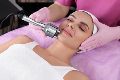 Young woman undergoing cosmetic procedure in beauty salon. Microcurrent therapy