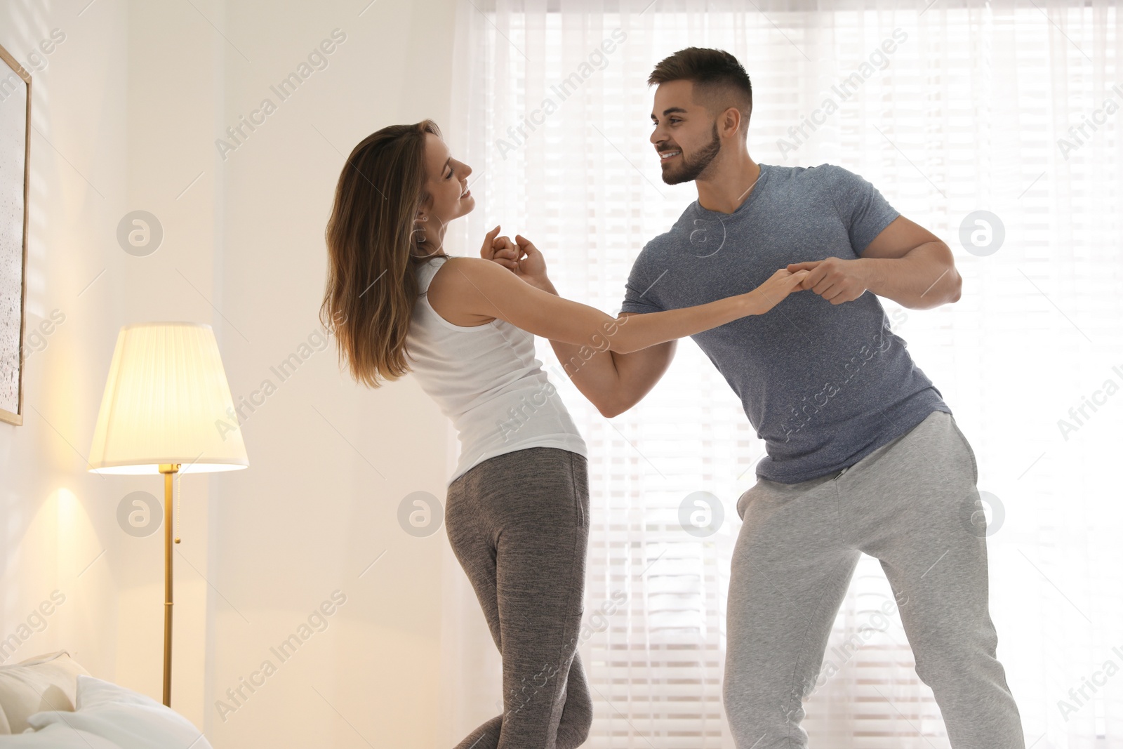 Photo of Lovely young couple dancing in bedroom at home