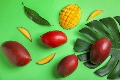 Photo of Flat lay composition with ripe mangoes and leaves on color background