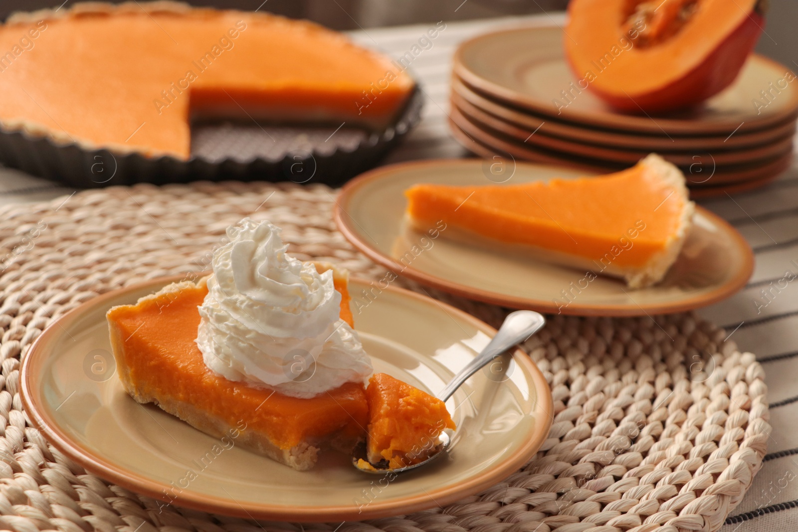 Photo of Piece of fresh homemade pumpkin pie with whipped cream on table