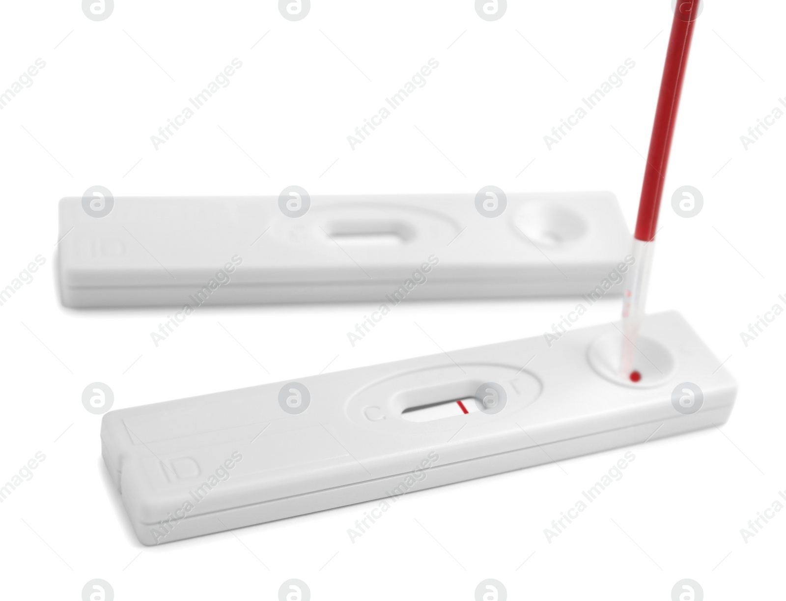 Photo of Dropping blood sample onto disposable express hepatitis test cassette with pipette on white background