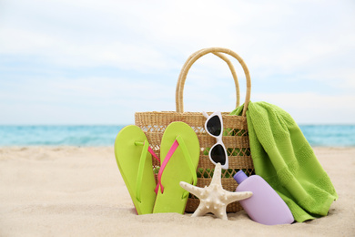 Photo of Different stylish beach objects and starfish on sand near sea