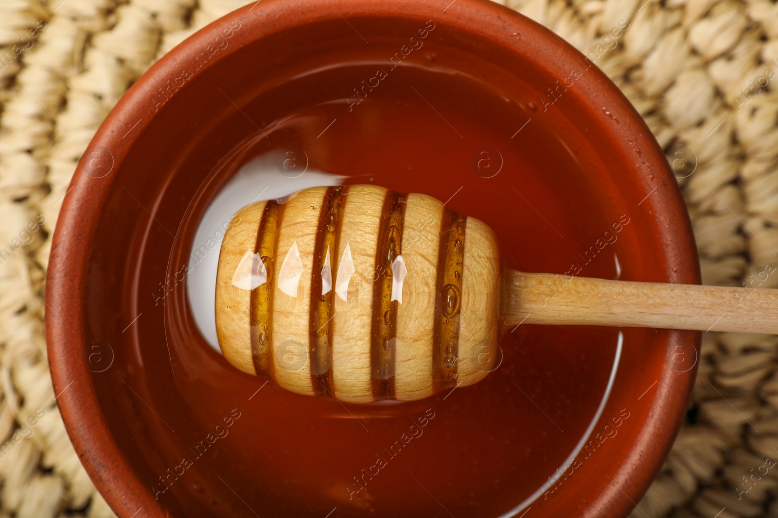 Photo of Dipper with honey in bowl on table, top view