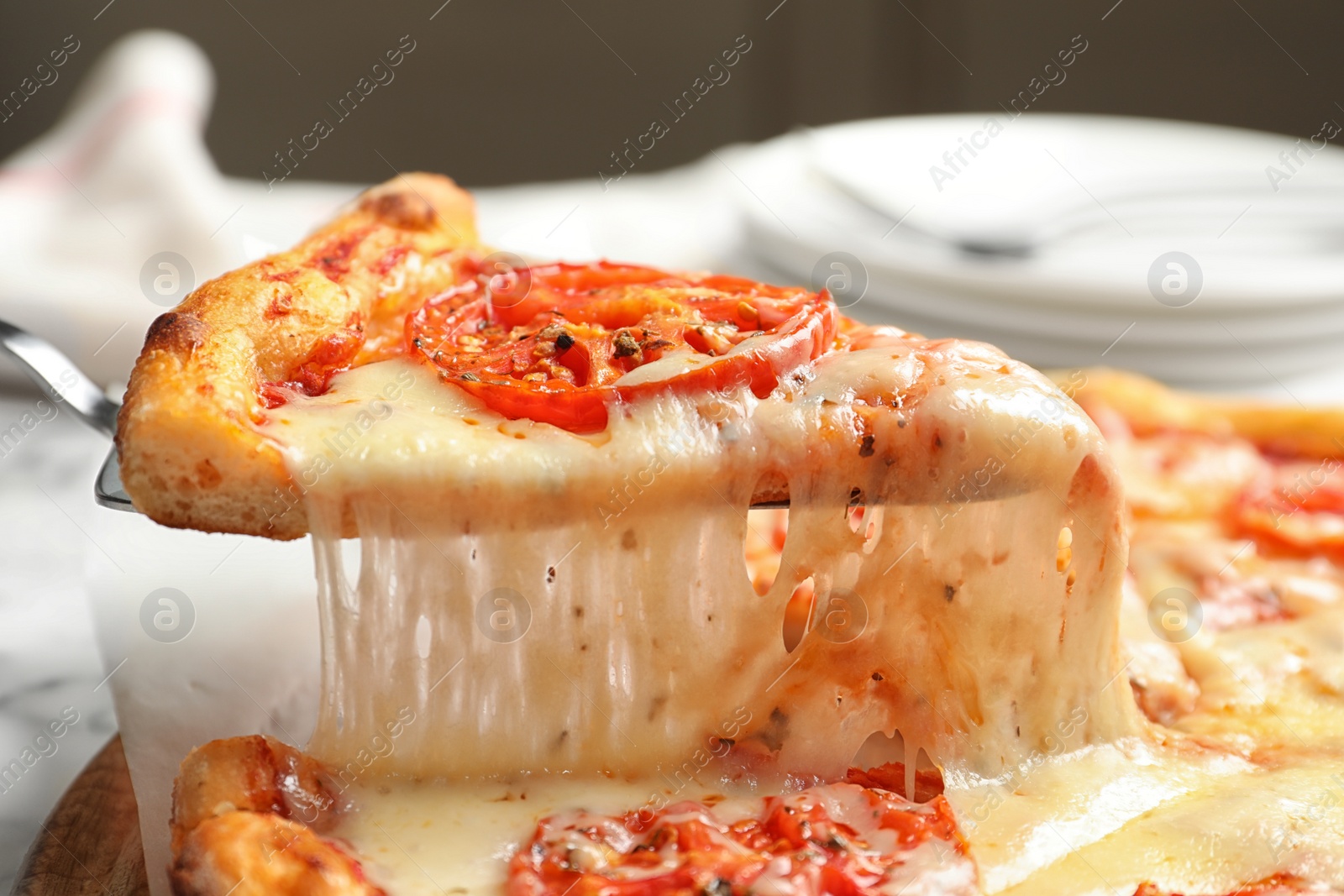 Photo of Taking slice of hot cheese pizza Margherita on table, closeup