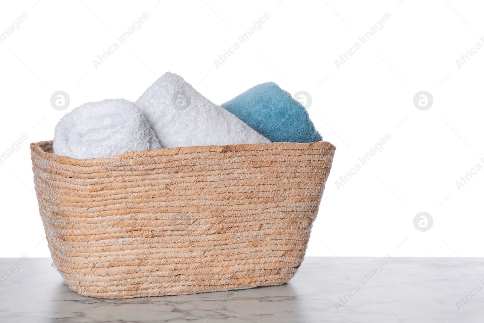 Photo of Soft towels in wicker basket on white background