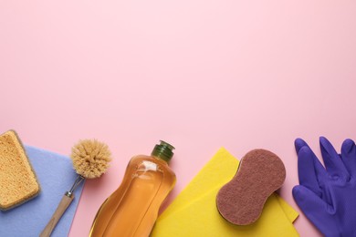 Photo of Flat lay composition with sponges and other cleaning supplies on pink background. Space for text