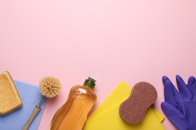 Flat lay composition with sponges and other cleaning supplies on pink background. Space for text