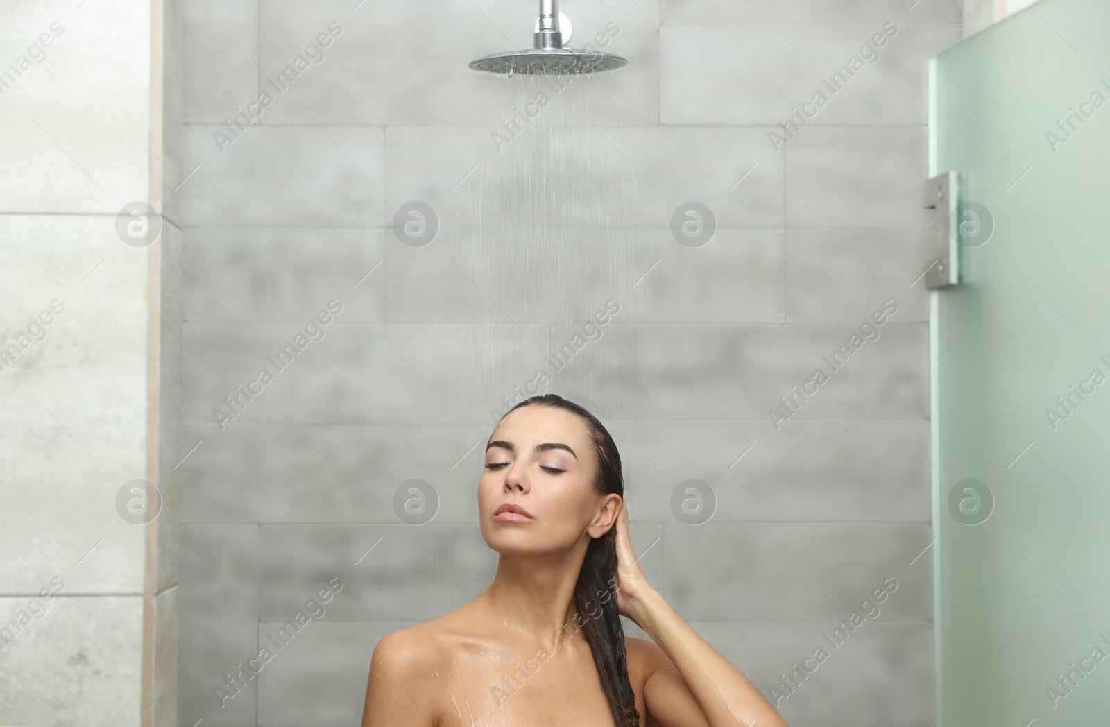 Photo of Beautiful young woman taking shower in spa center