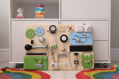 Photo of Busy board on floor indoors. Baby sensory toy