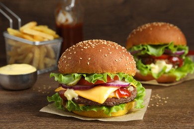 Photo of Delicious burgers with beef patty on wooden table