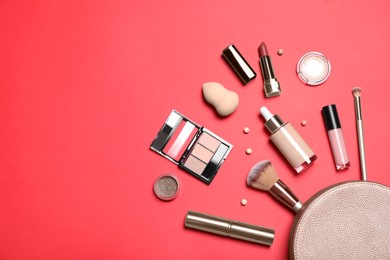 Photo of Different makeup products with cosmetic bag on red background, flat lay. Space for text