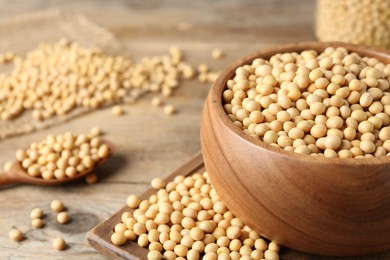 Natural soy beans on wooden table, closeup. Space for text