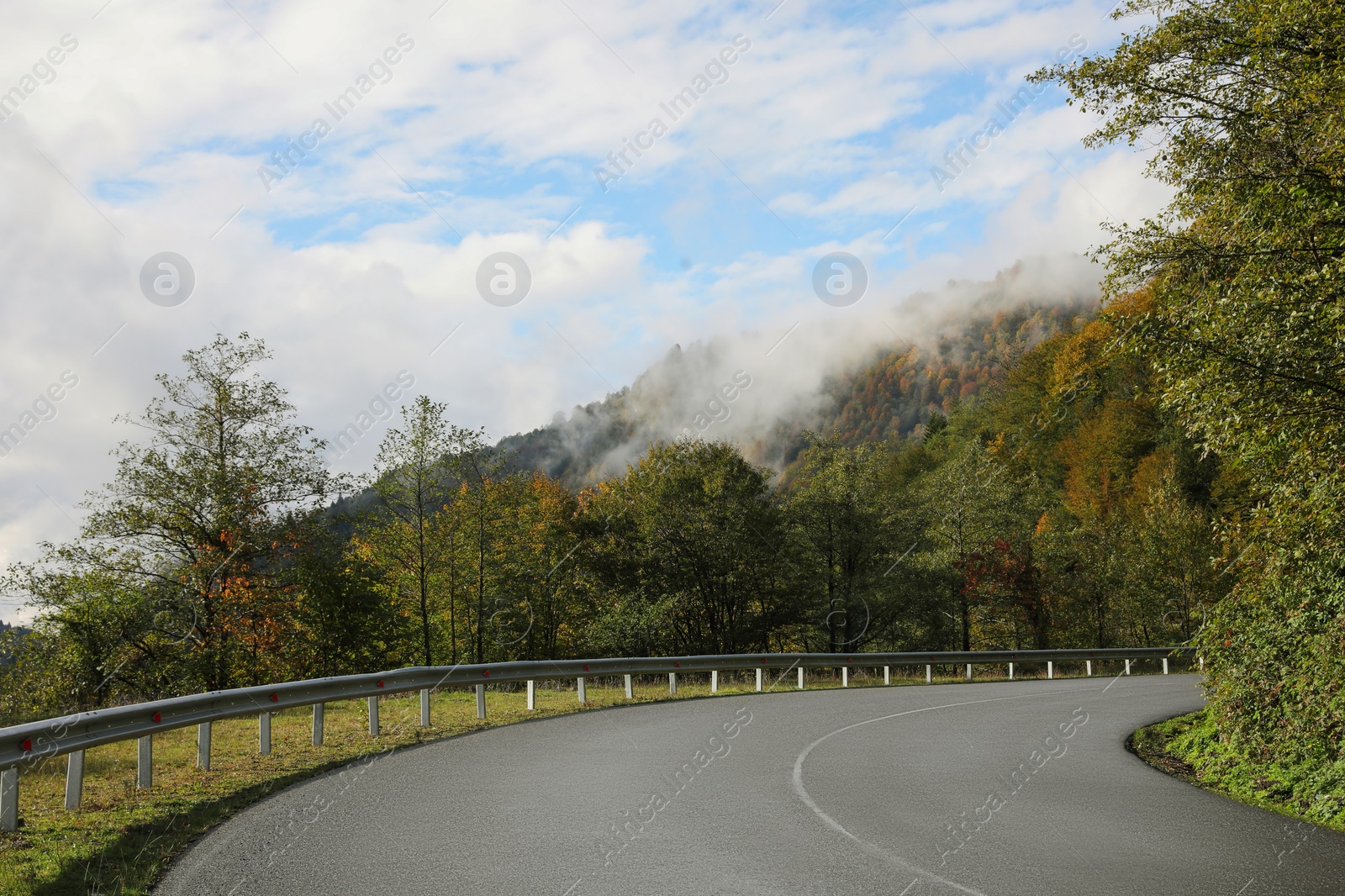 Photo of Picturesque view of empty road near trees in mountains