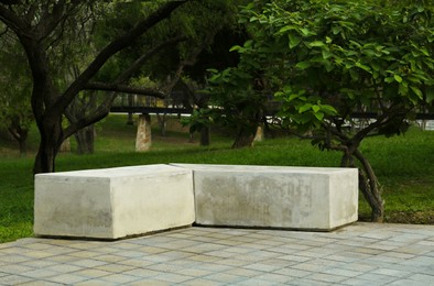 Photo of Picturesque view of beautiful park with concrete bench and trees