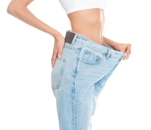 Photo of Slim young woman with smooth gentle skin in oversized jeans on white background, closeup. Beauty and body care concept