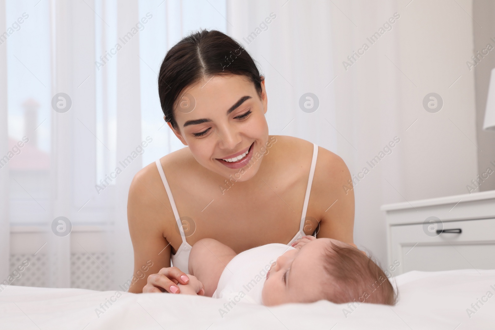 Photo of Young mother with her little baby at home