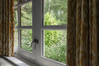 Photo of Old fashioned window with beautiful curtains in room. Interior design