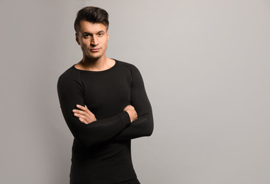 Photo of Man wearing thermal underwear on grey background. Space for text