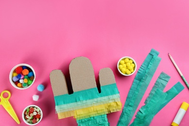 Photo of Cardboard cactus and materials on pink background, flat lay. Pinata DIY