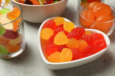 Photo of Delicious gummy candies on light grey table, closeup