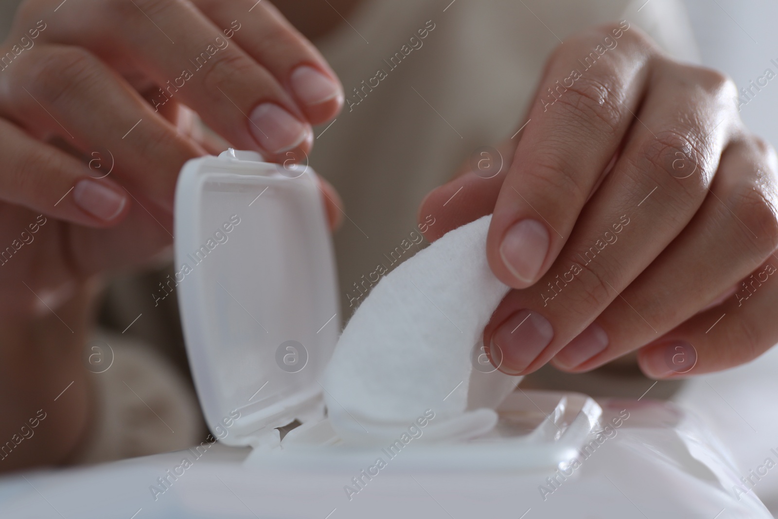 Photo of Woman taking wet wipe out of pack, closeup