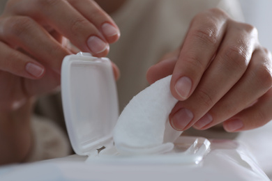 Photo of Woman taking wet wipe out of pack, closeup