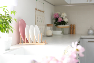 Photo of Clean plates on white countertop in modern kitchen. Interior design