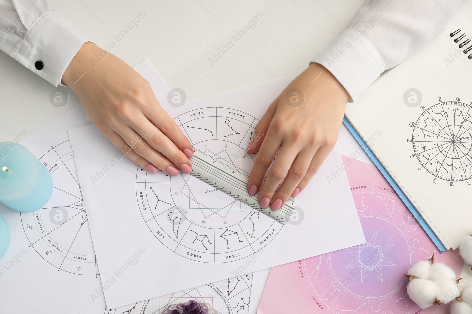 Photo of Astrologer using zodiac wheel for fate forecast at table, top view. Fortune telling