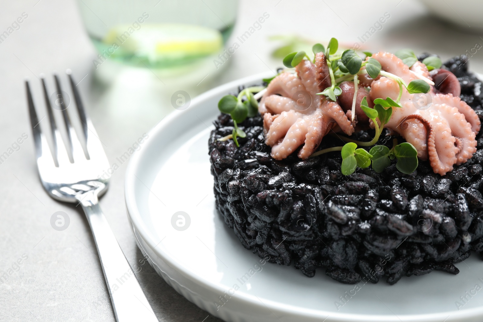 Photo of Delicious black risotto with seafood served on plate, closeup