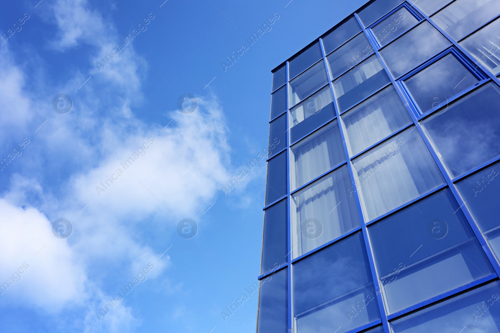 Photo of Modern office building with tinted windows against blue sky