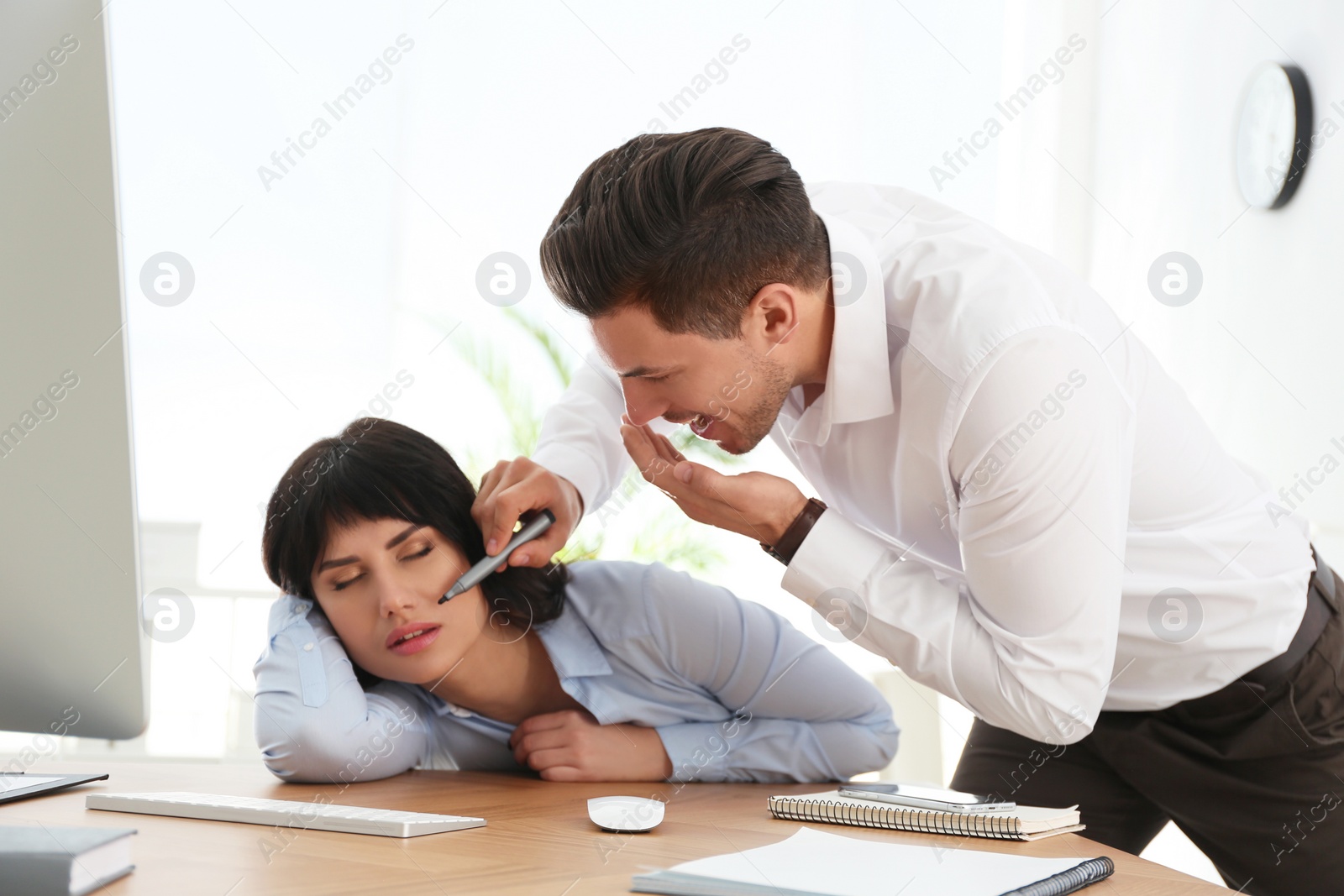 Photo of Man drawing on colleague's face while she sleeping at workplace. April fool's day