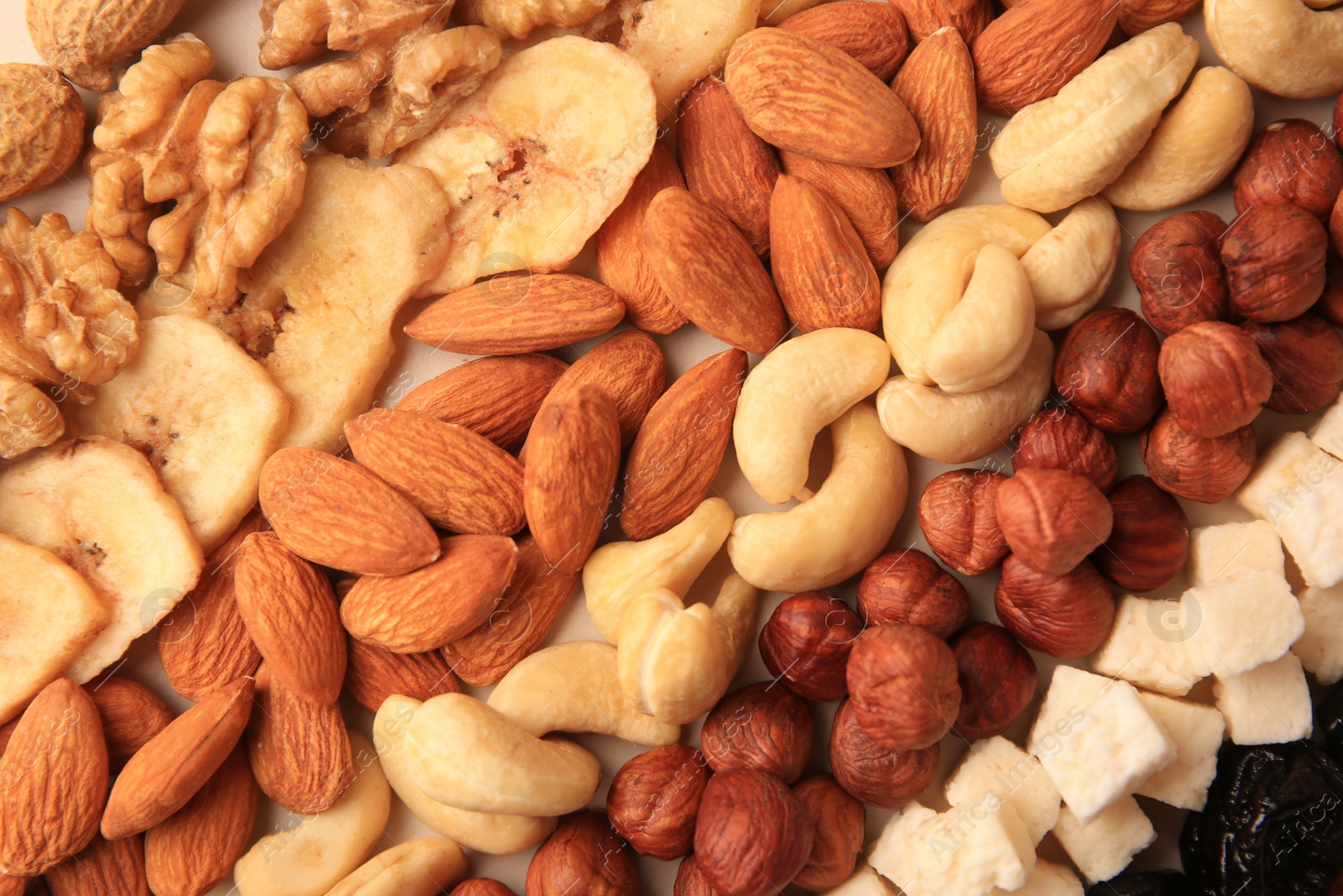 Photo of Different tasty nuts and dried fruits as background, top view