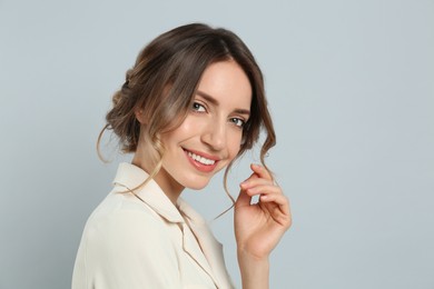 Photo of Young woman with beautiful hairstyle on light grey background