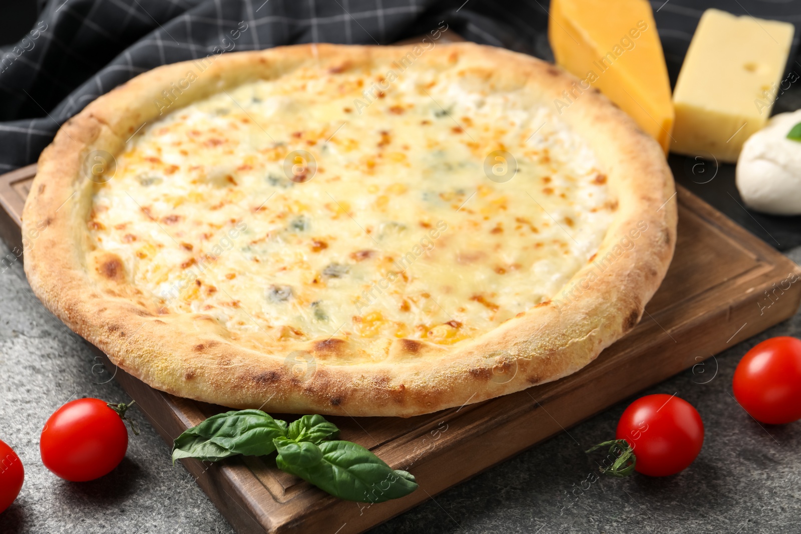 Photo of Delicious cheese pizza and ingredients on dark grey table