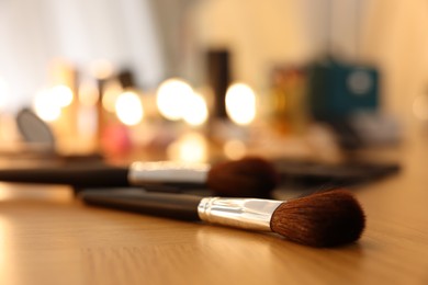 Makeup brush on wooden dressing table indoors