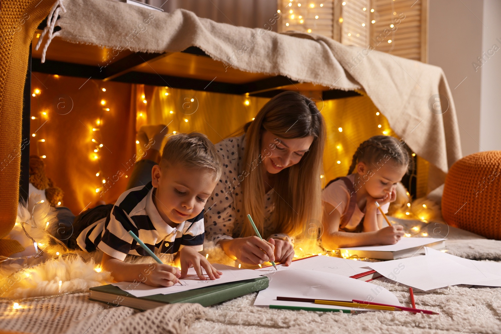 Photo of Mother and her children drawing in play tent at home