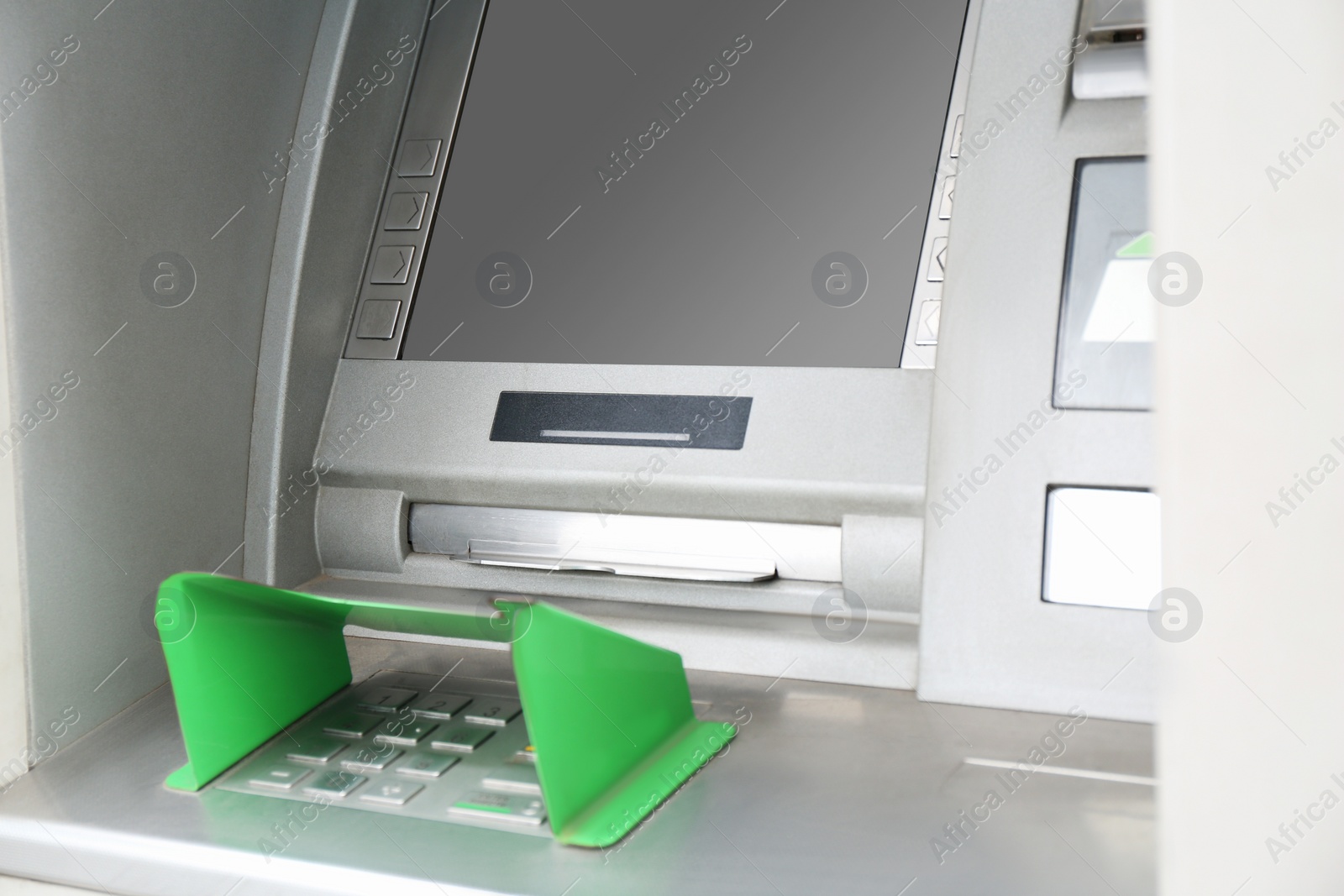 Photo of Modern automated cash machine with screen and keypad