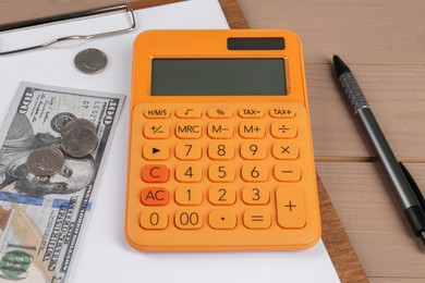 Photo of Orange calculator, money, clipboard with paper sheet and pen on table. Retirement concept